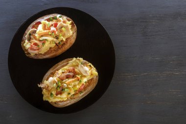 Jambon ve mantar bir ahşap tahta üzerinde rustik bir şekilde fırında patates. Yakın çekim. Uzay kopyalayın. Üstten görünüm