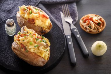 Jambon ve mantar rustik tarzda bir siyah plaka ile fırında patates. Yakın çekim.