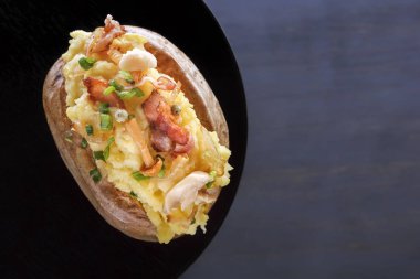 Jambon ve mantar bir ahşap tahta üzerinde rustik bir şekilde fırında patates. Yakın çekim. Uzay kopyalayın. Üstten görünüm