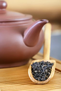 Çay granül bir ahşap tepsi öznitelikleri bir geleneksel çay töreni için arka planı üzerinde özel çay kaşığı yalan içine döktü. Yakın çekim