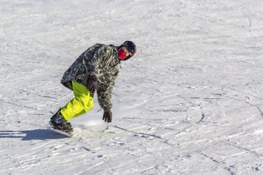 snowboard hızlı bir şekilde mavi gökyüzü karşı gevşek karda dağdan güneşli bir günde alır. Kopya alanı