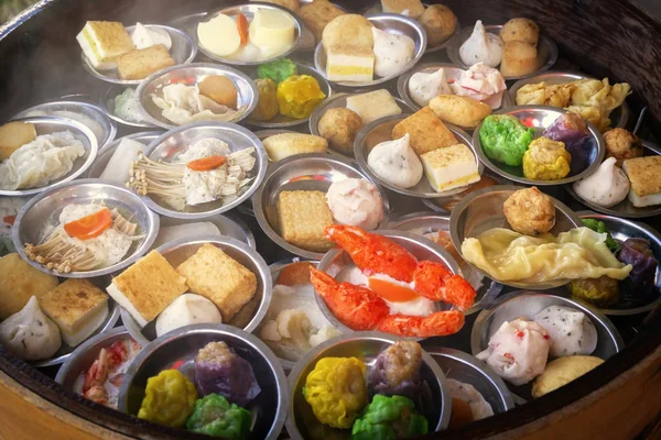 Os pratos asiáticos tradicionais cozinharam no vapor em uma cesta de bambu - verduras, cogumelos, camarões, massa de farinha. Comida de rua . — Fotografia de Stock