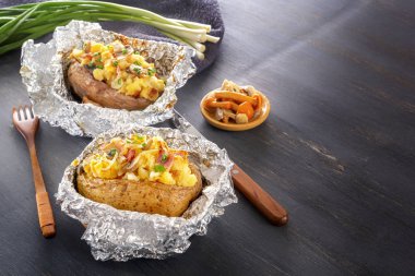 Fırında patates folyo ile pastırma, soğan ve mantar gri bir ahşap masa üzerinde. Kopya alanı.