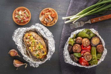 Fırında patates ile pastırma, soğan ve pişmiş sebze folyo - domates, patlıcan, biber üzerinde gri bir ahşap masa. Üstten Görünüm