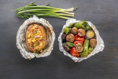 Pişmiş sebze folyo - domates, patlıcan, biber ve fırında patates pastırma, soğan üzerinde gri bir ahşap masa. Üstten Görünüm