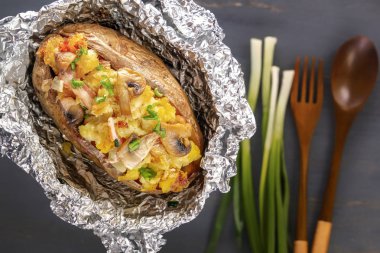 Fırında patates folyo ile pastırma, soğan ve mantar ile çatal üzerinde gri bir ahşap masa. Yakın çekim. Üstten Görünüm