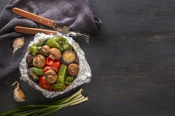 Pişmiş sebze folyo - domates, patlıcan, biber üzerinde gri bir ahşap masa. Uzay kopyalayın. Üstten Görünüm