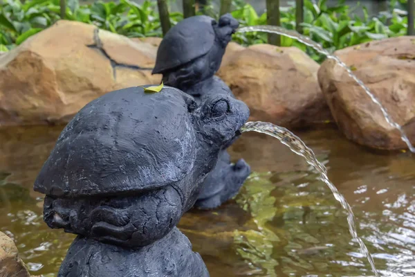 Питьевой фонтан, сделанный в виде каменных черепах, стоящих друг на друге. Копирование пространства — стоковое фото