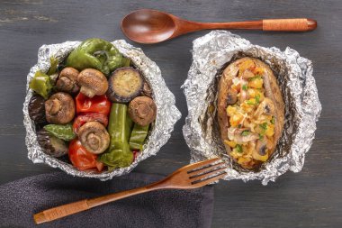 Pişmiş sebze folyo - domates, patlıcan, biber ve fırında patates pastırma, soğan üzerinde gri bir ahşap masa. Üstten Görünüm