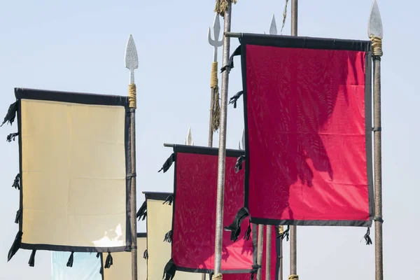 Banderas blancas y rojas en blanco sobre picos militares estilizados de la Edad Media sobre un fondo liso. Prepárate. Copiar espacio — Foto de Stock