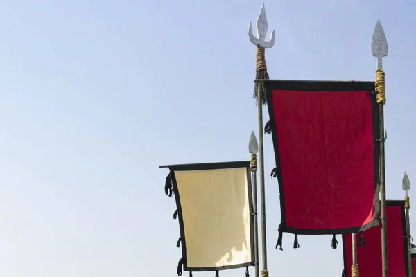 Banderas blancas y rojas en blanco sobre picos militares estilizados de la Edad Media sobre un fondo liso. Prepárate. Copiar espacio — Foto de Stock