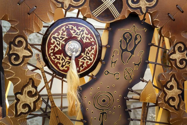 Ulusal sembollerin arka planına karşı bir at tüyü fırçası ile eski bir Asya savaşçısının geleneksel kalkanı