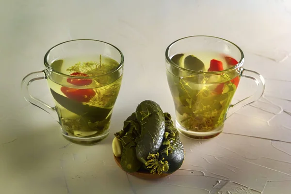 Dos vasos con pepino en vinagre y pepinos en vinagre en un plato de madera —  Fotos de Stock