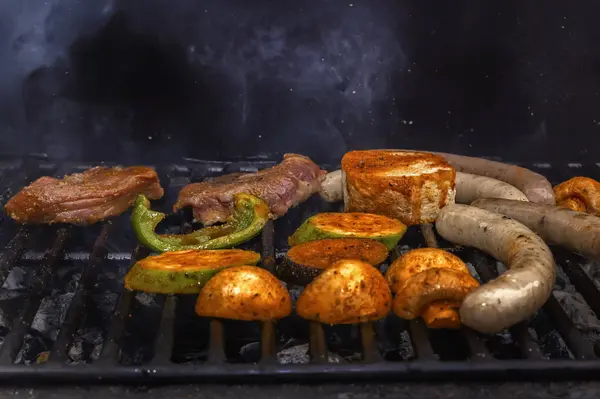 Embutidos, bistec de carne, verduras, setas se cocinan en una parrilla de carbón. Comida callejera. Primer plano —  Fotos de Stock