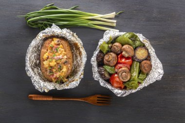 Fırında patates ile pastırma, soğan ve pişmiş sebze folyo - domates, patlıcan, biber üzerinde gri bir ahşap masa. Üstten Görünüm