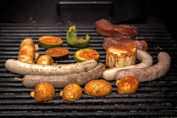 Embutidos, bistec de carne, verduras, setas se cocinan en una parrilla de carbón. Comida callejera. Primer plano —  Fotos de Stock