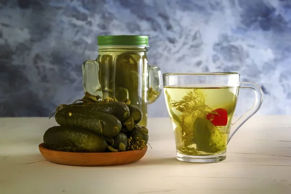 Cam bardak ve ahşap masa üzerinde salatalık turşusu ile birlikte salatalık turşusu bir kavanoz. Kopyalama alanı