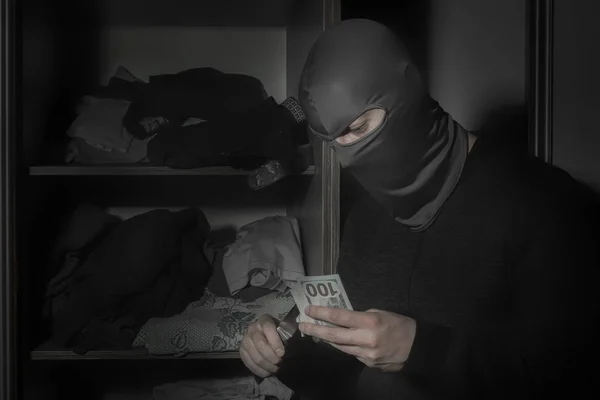 Ladro in maschera con un coltello e con una torcia ruba soldi — Foto Stock