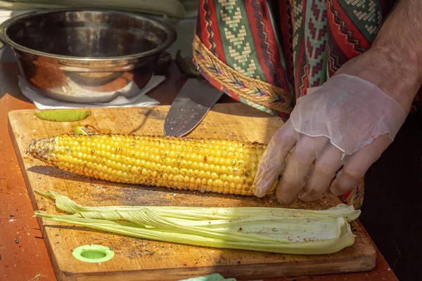 Cocine en la tabla de cortar prepara mazorca de maíz asado para el comprador — Foto de Stock