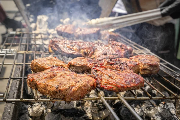 Yanan kömürler üzerinde duman ızgara üzerinde biftek pişirme — Stok fotoğraf