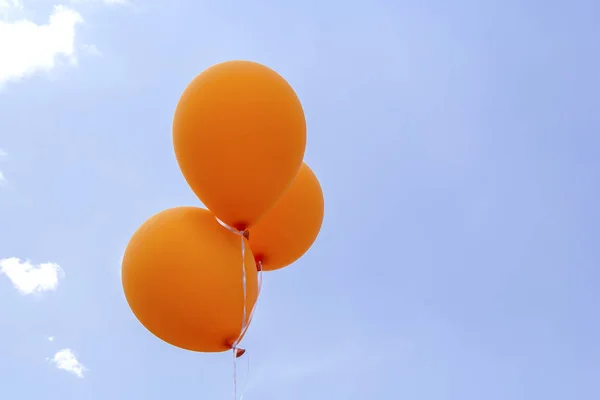Bando de balões laranja no céu azul com nuvens — Fotografia de Stock