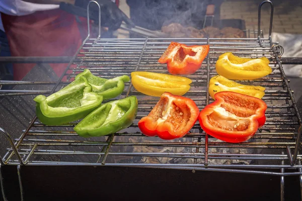 Pimenta de sino vermelha, amarela e verde frita em uma grelha sobre carvão vegetal — Fotografia de Stock