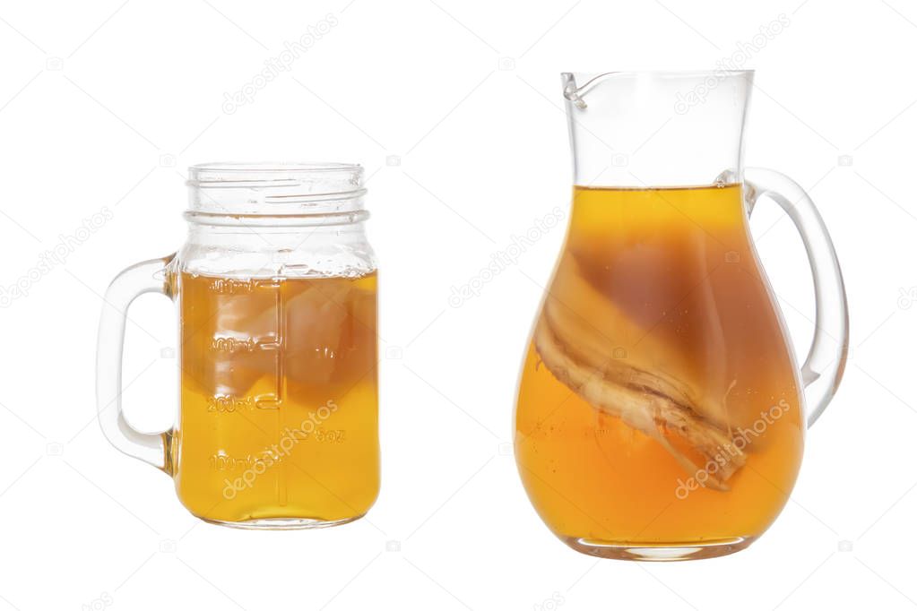 Homemade fermented drink Kombucha in a glass jug and jar. Isolated on white background