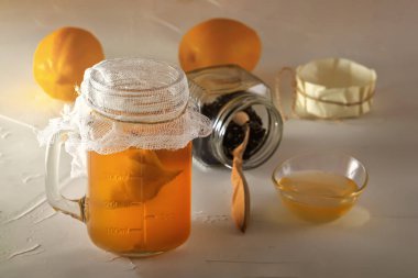 Ahşap masada limon, bal ve zencefil ile cam kavanozda ev yapımı fermente içecek kombucha. Close