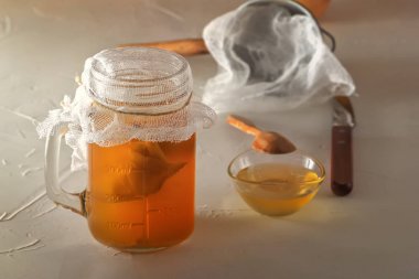 Ahşap bir masada bal ile cam kavanozda ev yapımı fermente içecek kombucha. Close