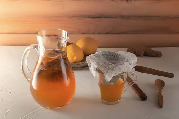 Bebida fermentada casera Kombucha en frascos de vidrio con limón y jengibre sobre una mesa de madera . —  Fotos de Stock