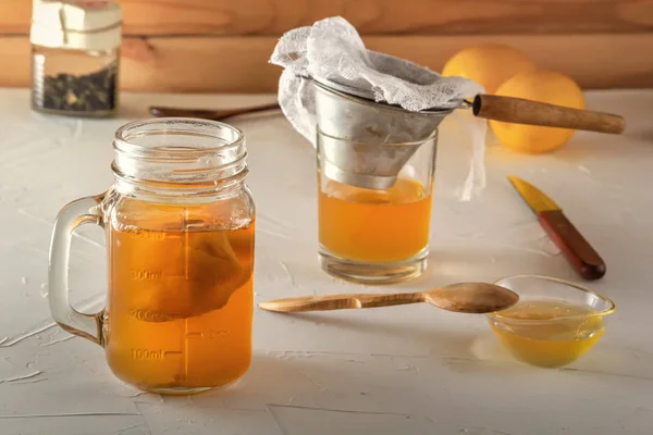 Bebida fermentada casera Kombucha en frascos de vidrio con limón, miel y jengibre sobre una mesa de madera . —  Fotos de Stock