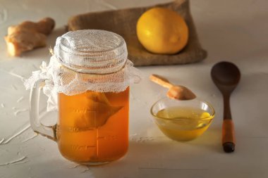 Ahşap masada limon, bal ve zencefil ile cam kavanozda ev yapımı fermente içecek kombucha. Close