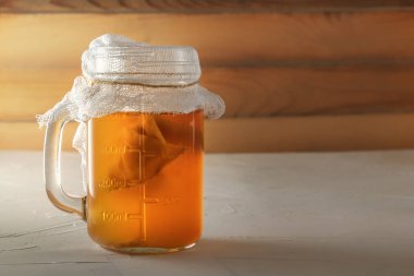 Ev yapımı fermente içki Kombucha ahşap bir masada bir cam sürahi. Boşluk Kopyala