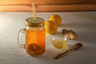 Ahşap masada limon, bal ve zencefil ile cam kavanozda ev yapımı fermente içecek kombucha. Close
