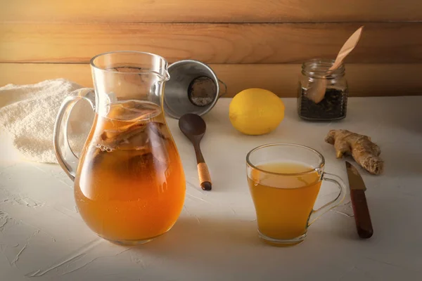 Bebida fermentada casera Kombucha en frascos de vidrio con limón y jengibre sobre una mesa de madera . — Foto de Stock