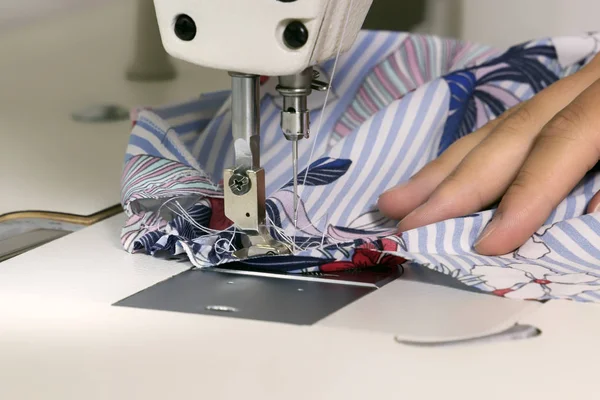 Vrouw kleermaker naait stof op een naaimachine in de werkplaats. Close-up. Ruimte kopiëren — Stockfoto