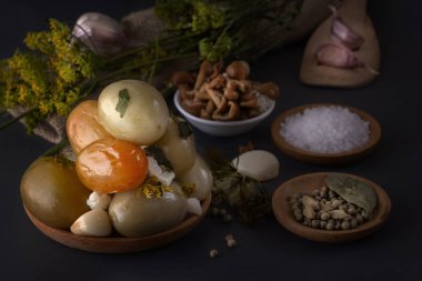 Tuzlu domates tuzlama için baharat ile birlikte koyu bir masada ahşap bir tabakta. Kopya alanı. Düşük anahtar.