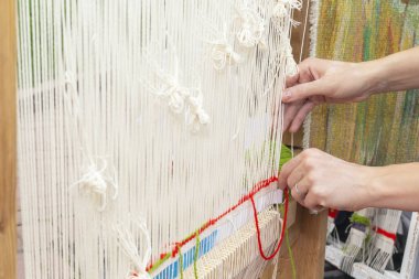 Dişi eller bir el tezgahında iplik iplik. Kopyalama alanı