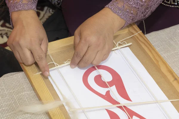 Handen van de meester weven nationale Kazachse patronen in een houten frame. Close-up — Stockfoto