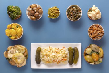 Fermente ürünler lahana, biber, turşu, domates, mantar, kabak, sarımsak mavi bir masada. Üst te. Kopyalama alanı