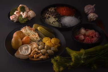 Fermente gıdalar lahana, biber, turşu, domates, mantar, kabak, sarımsak tuzlama için baharat ile koyu bir masada büyük bir ahşap çanak. Düşük anahtar.