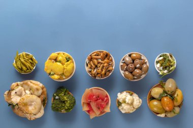 Fermente ürünler lahana, biber, turşu, domates, mantar, kabak, sarımsak mavi bir masada. Üst te. Kopyalama alanı