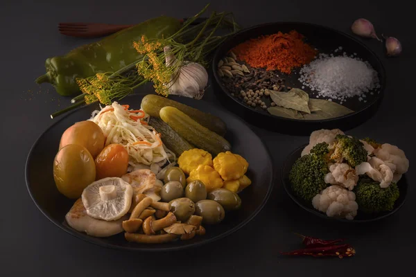 Fermente gıdalar lahana, biber, turşu, domates, mantar, kabak, sarımsak tuzlama için baharat ile koyu bir masada büyük bir ahşap çanak. Düşük anahtar.