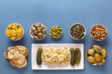 Fermente ürünler lahana, biber, turşu, domates, mantar, kabak, sarımsak mavi bir masada. Üst te. Kopyalama alanı