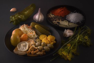Fermente gıdalar lahana, biber, turşu, domates, mantar, kabak, sarımsak tuzlama için baharat ile koyu bir masada büyük bir ahşap çanak. Düşük anahtar.