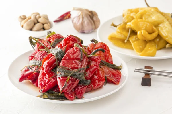 Традиционная корейская ферментированная пища - красный острый перец с травами на белом столе. Крупный план — стоковое фото