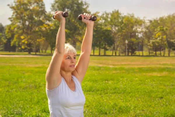 Une Femme Âgée Soulève Des Haltères Tout Faisant Remise Forme — Photo