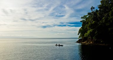close-up view of fishermen with the horizon, sky and islands in the background, Lubang Buaya beach, Maluku