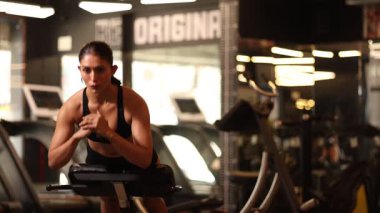 Jimnastik salonundaki bir kız karın kaslarına ve bel kaslarına odaklanarak vücut geliştirme ameliyatı yapıyor..