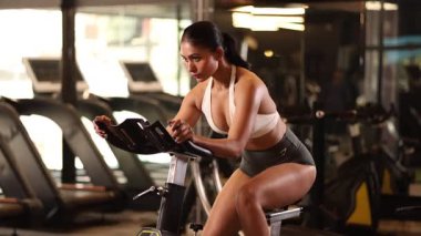 Atletik bir kız bisiklet sürüyor, dayanıklılık ve güç kazanıyor..